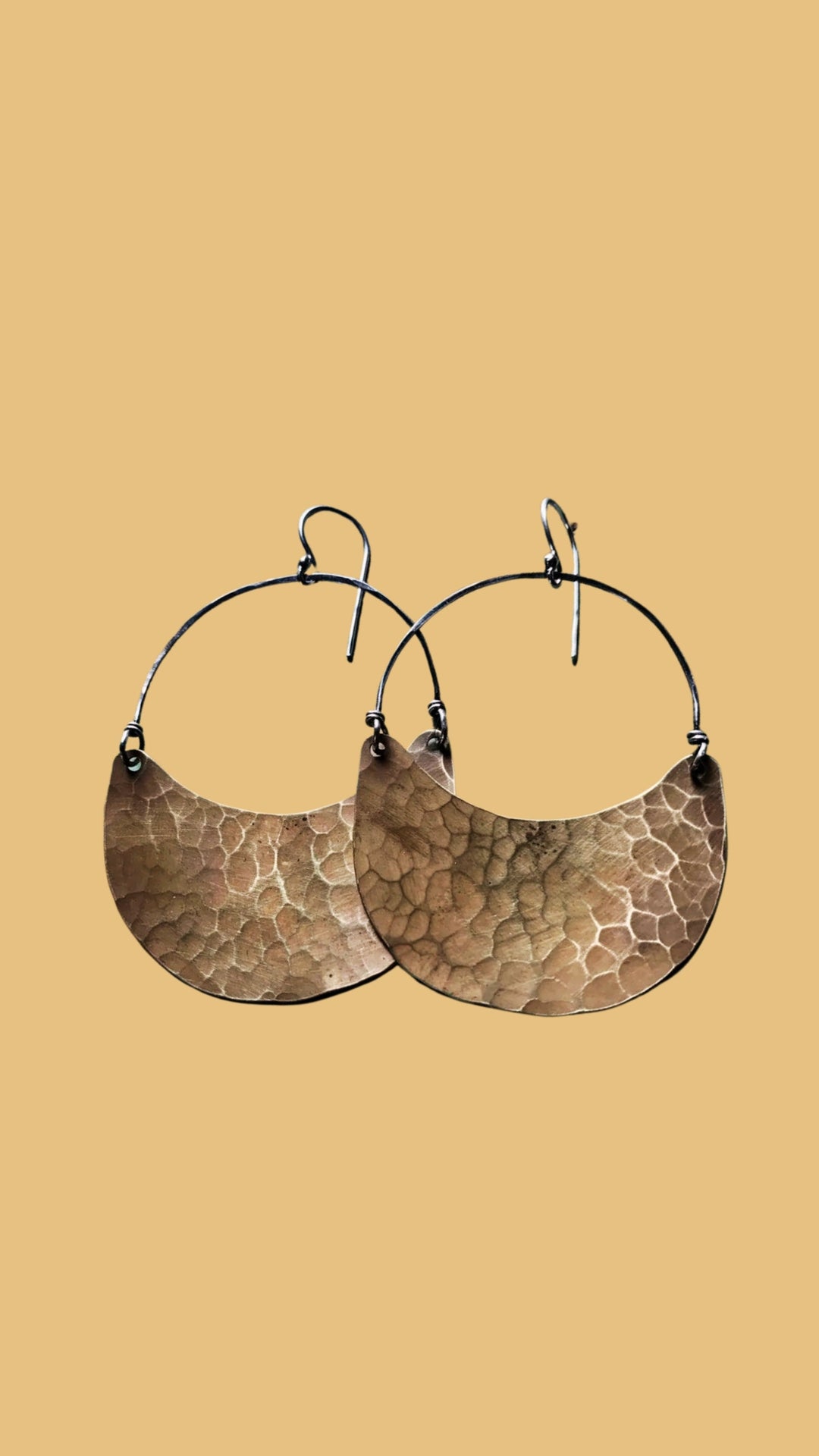 A pair of feather brass earrings with chains made by Jennifer Kahn