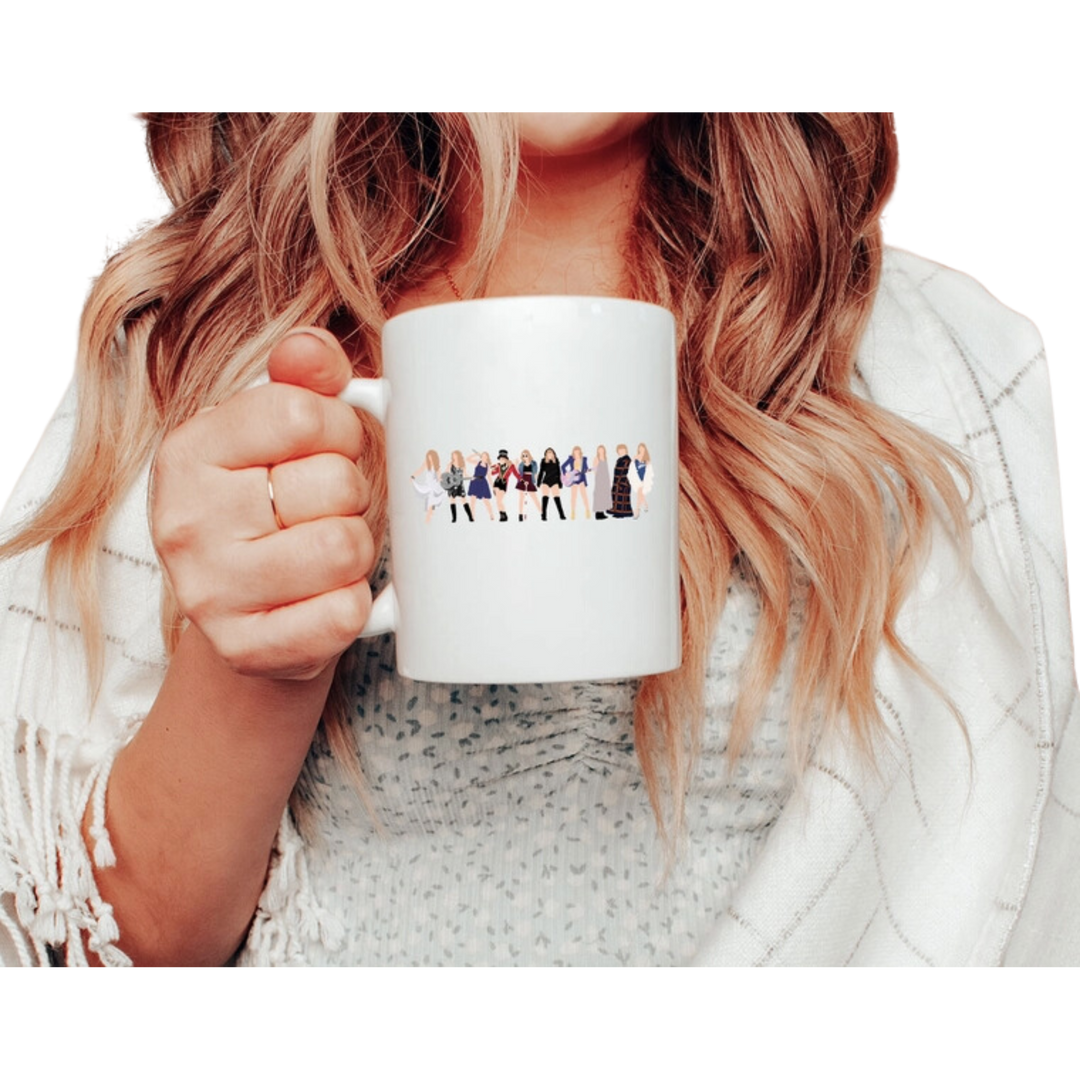 White mug with cartoon Taylor Swift outfits. Taylor Era's Coffee Mug features a design inspired by Pop Music - and is double-sided for extra appeal. It is top-rack dishwasher safe, making it a convenient kitchen accessory.