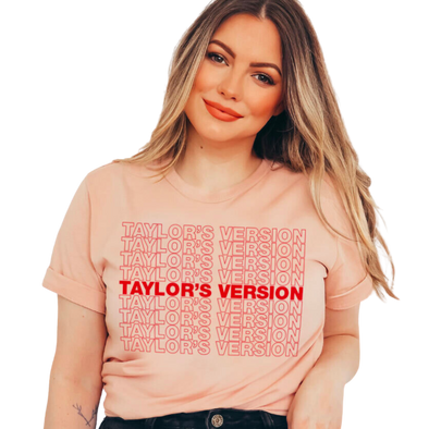 Pink shirt with red outline text "Taylor's Version". Taylor's unisex crew neck t-shirt is crafted with lightweight cotton for enduring comfort. Printed with water-based inks, it won't fade or crack. Additionally, these inks are non-toxic, so you can show your style confidently. Proudly made in the USA.