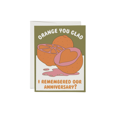 Orange with heart cutout on a green and white background with text "Orange You Glad I Remembered Our Anniversary?". 100-lb heavy card stock, offset printed at 5.5" x 4.25", illustrated by Clay Hickson, and made in the United States.
